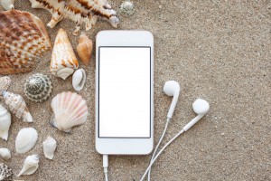 Phone,With,Isolated,Screen,And,Headphones,Lying,On,The,Sand